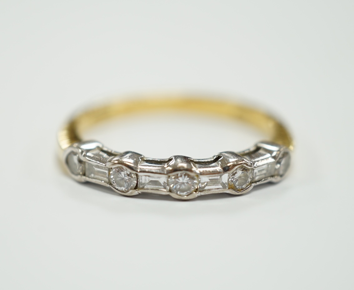 A modern 18ct gold, round and baguette cut diamond set half hoop ring, size N/O, gross weight 3.2 grams.